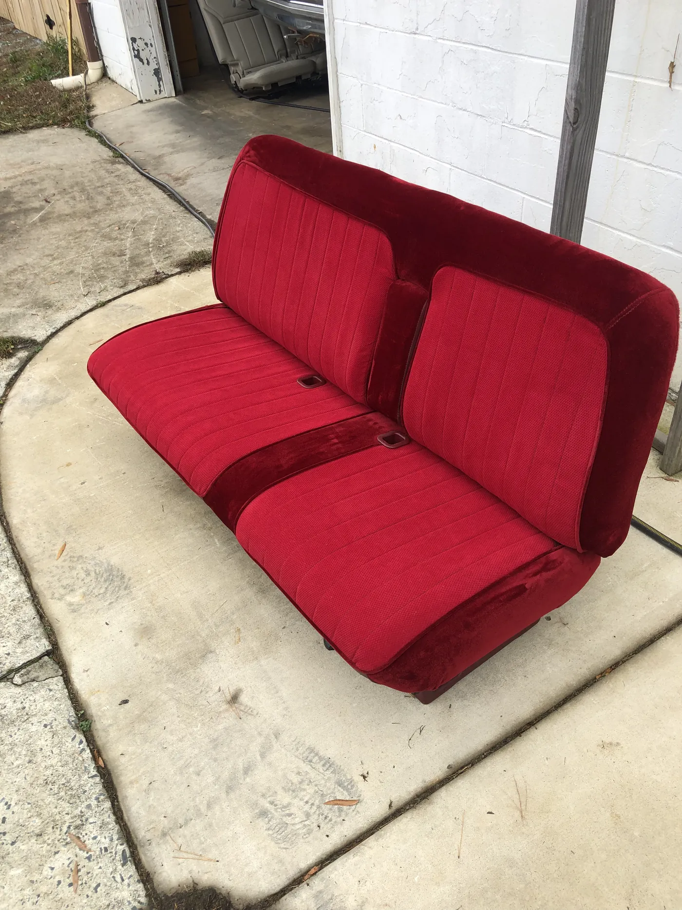 A two-tone red bench seat finished and out on the driveway