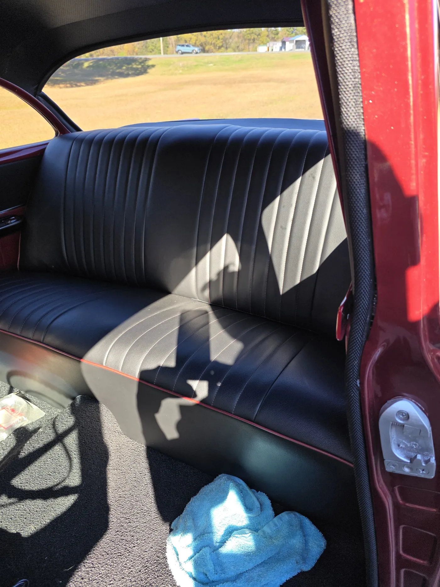 Dark pleated door trim and seats inside a red classic