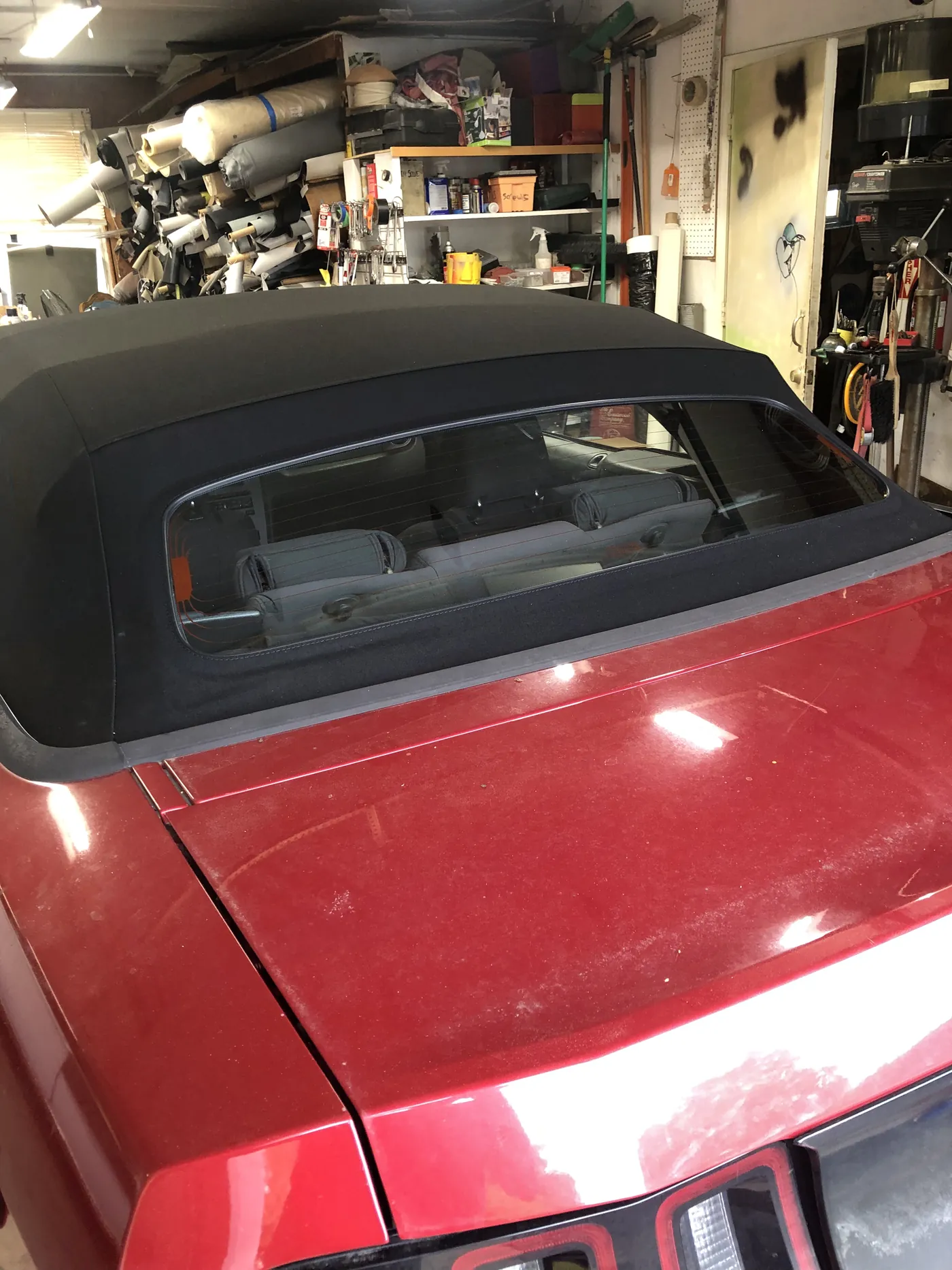 A red convertible with its new black top, photographed in the bay
