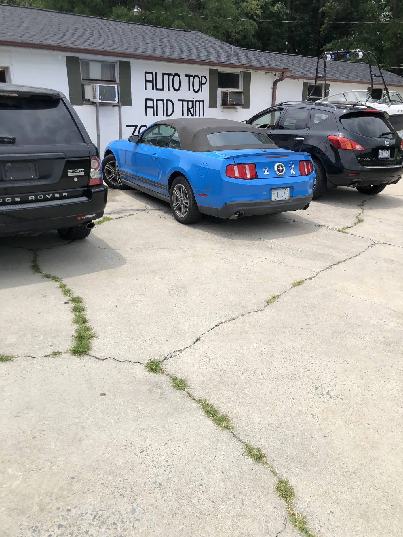 A blue Camaro convertible parked outside the Monroe shop