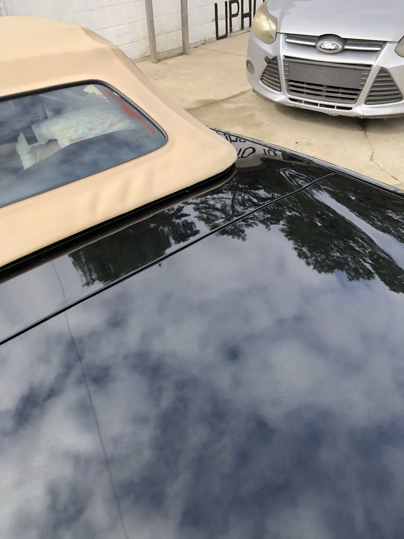 A tan convertible top with its glass rear window