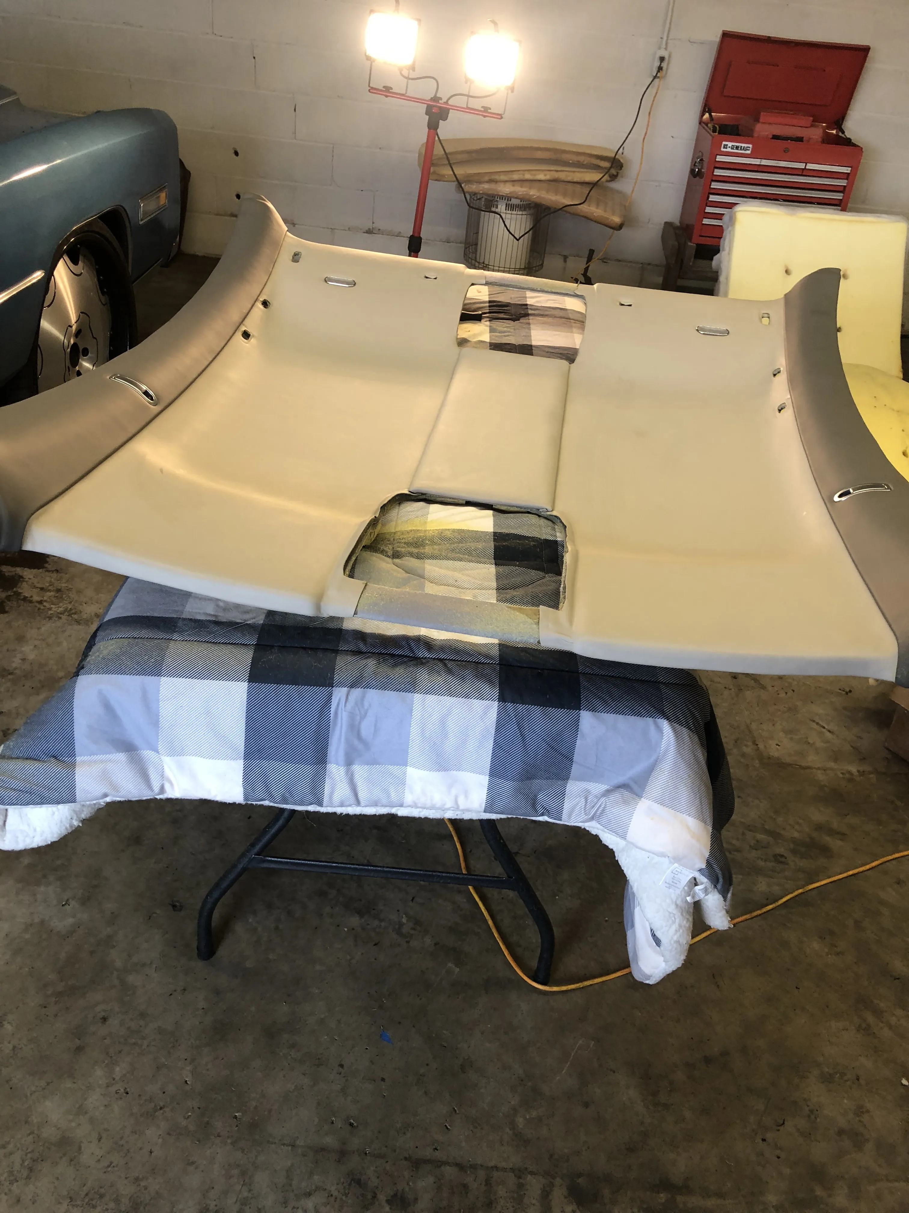 A cream headliner panel on the shop table