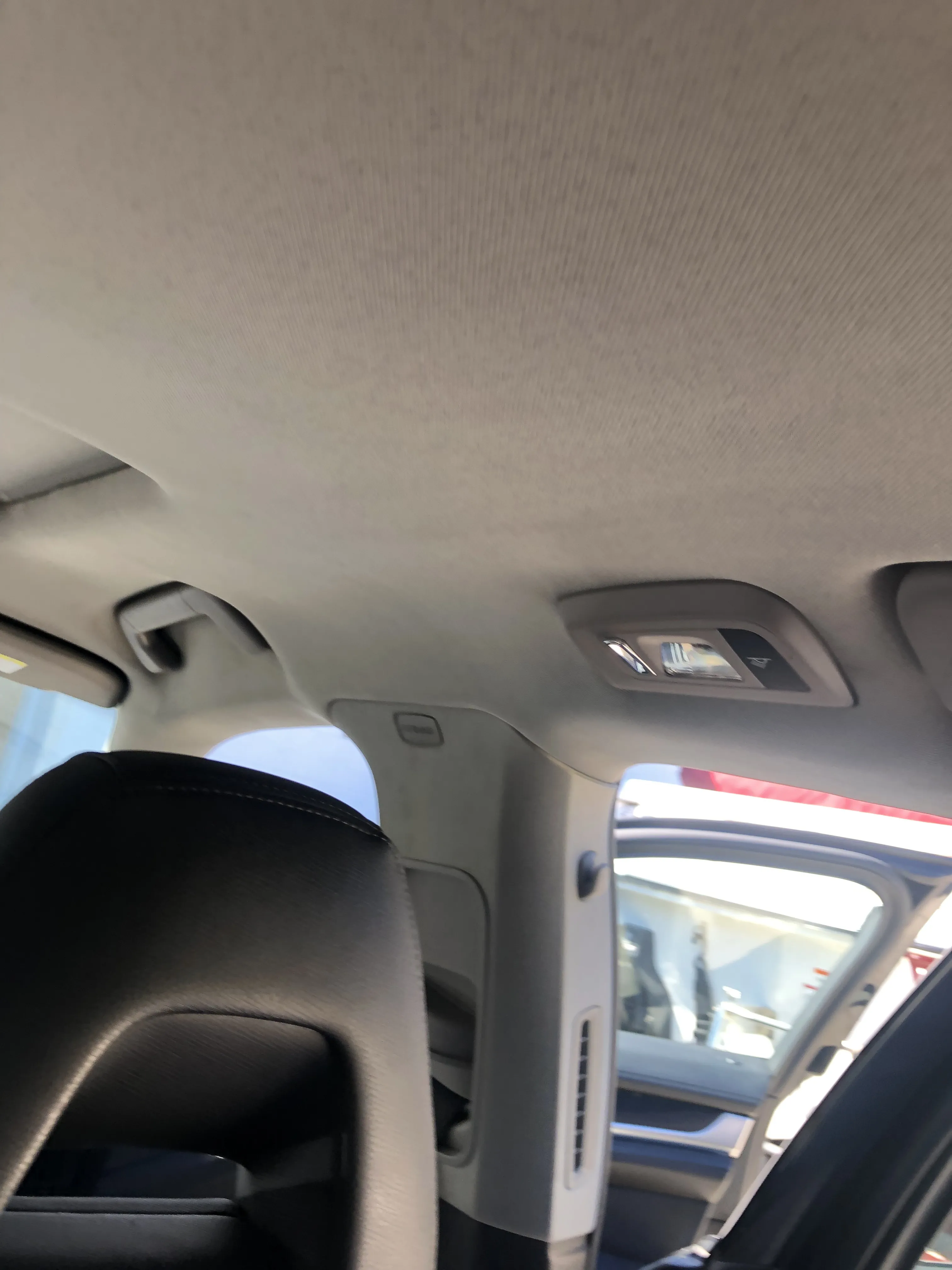 A finished headliner at the rear quarter and grab handle