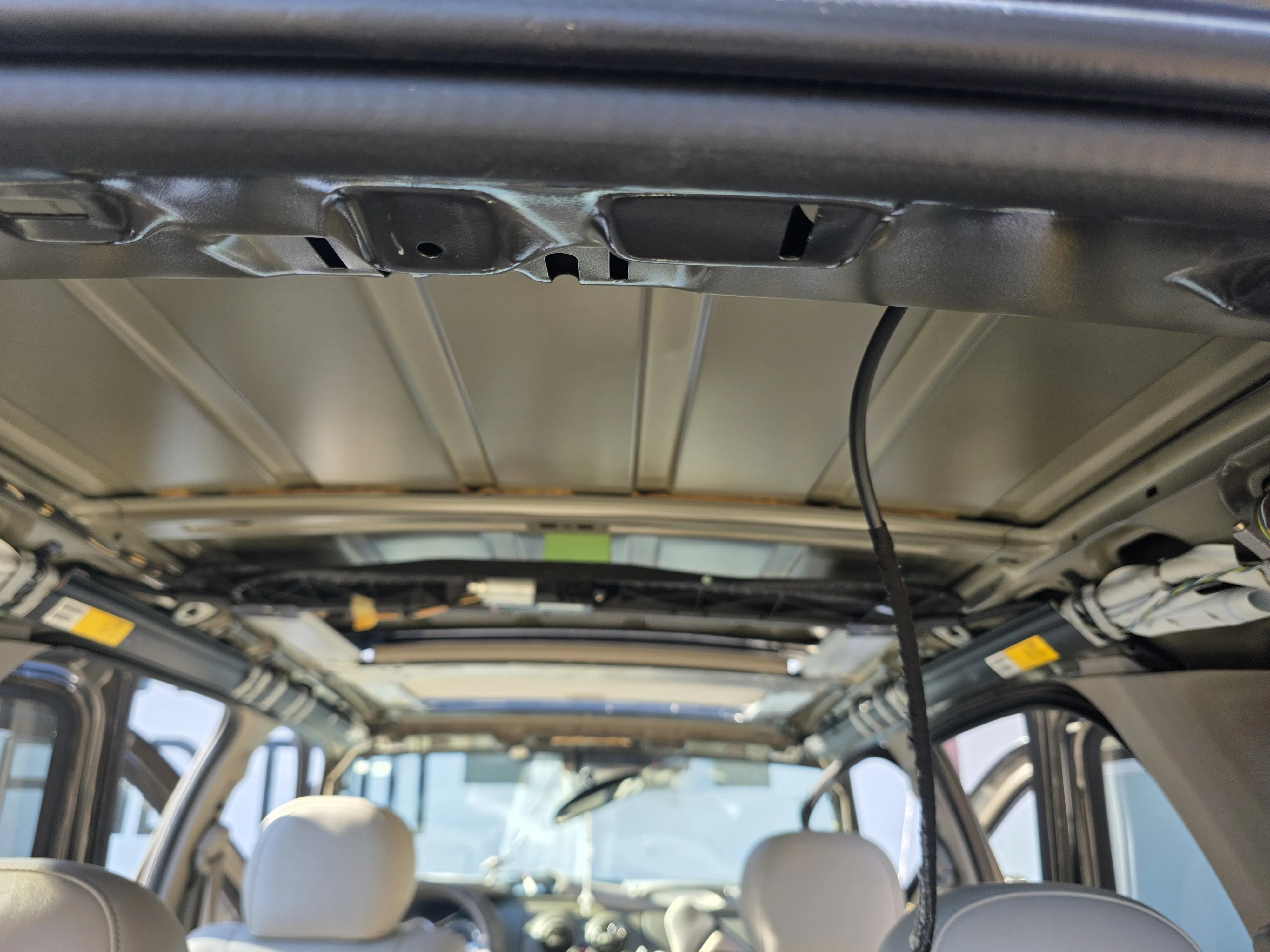 An SUV roof with the headliner out and the bows exposed